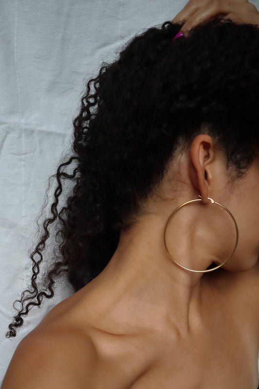 Model wearing 70mm 18K gold plated hoop earrings