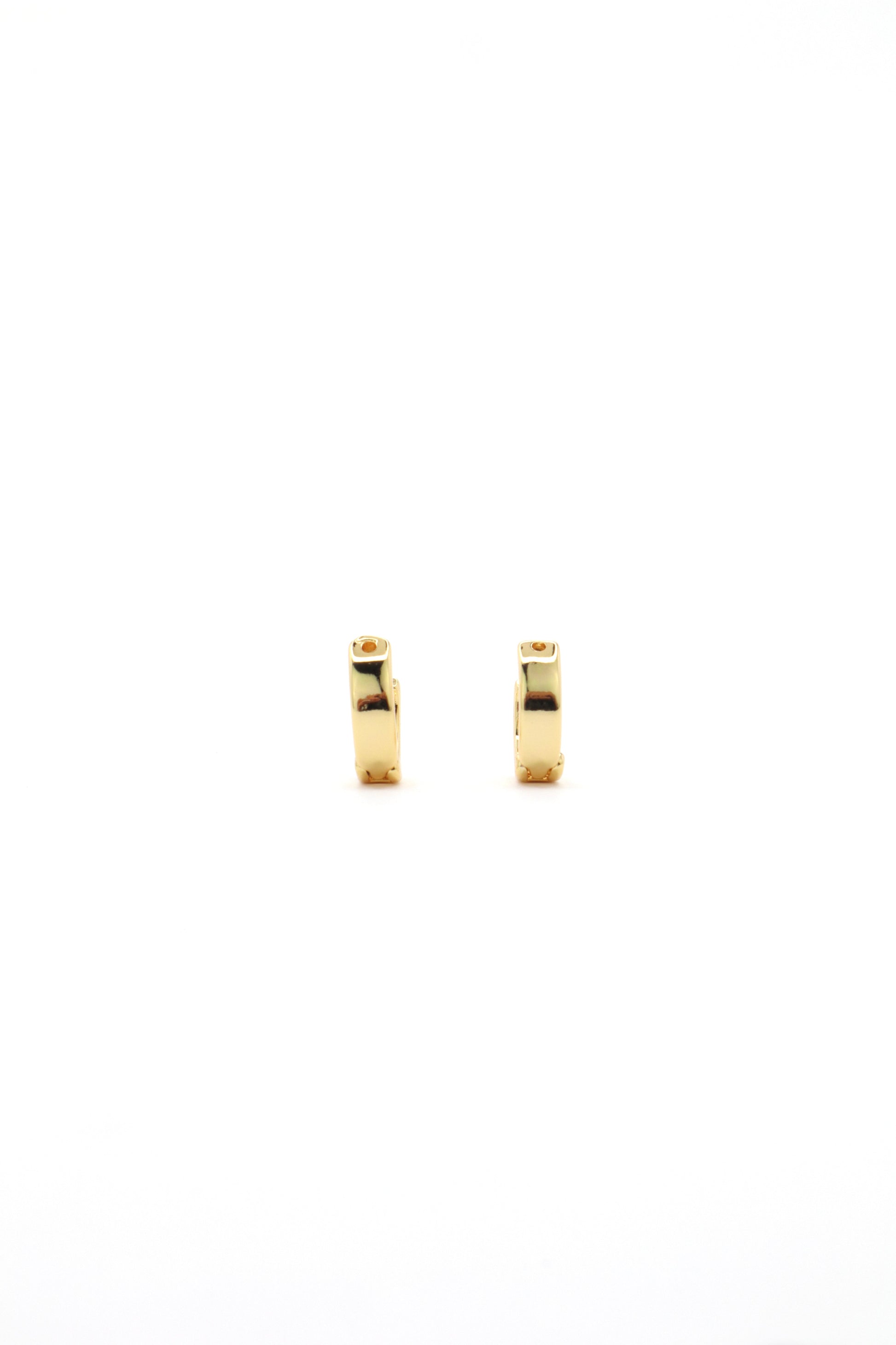 Close-up of 18K gold plated 11mm huggies earrings on white backgorund by Nayda De Jesus