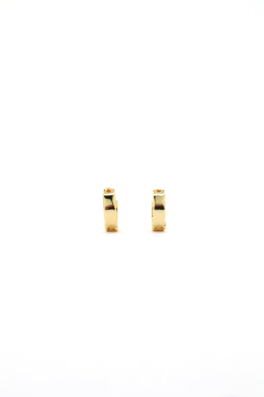 Close-up of 18K gold plated 11mm huggies earrings on white backgorund by Nayda De Jesus