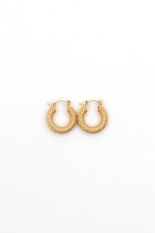 Close-up of 18K gold plated 20mm twisted hoop earrings on white background by Nayda De Jesus