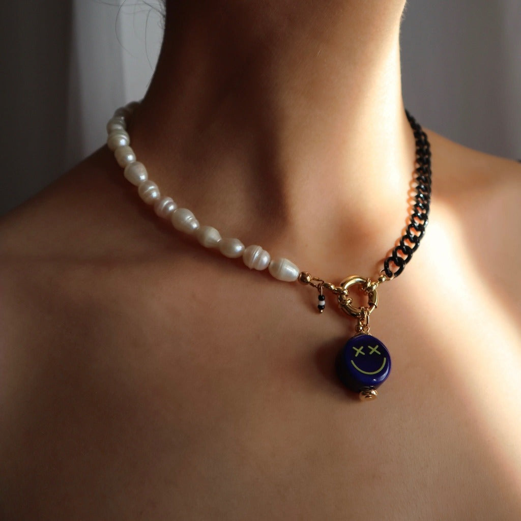 Freshwater pearls and black chain necklace displayed on model with ceramic smiley face pendant charm