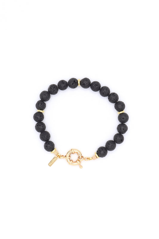Black lava bead and gold bracelet handmade on white background by Nayda De Jesus