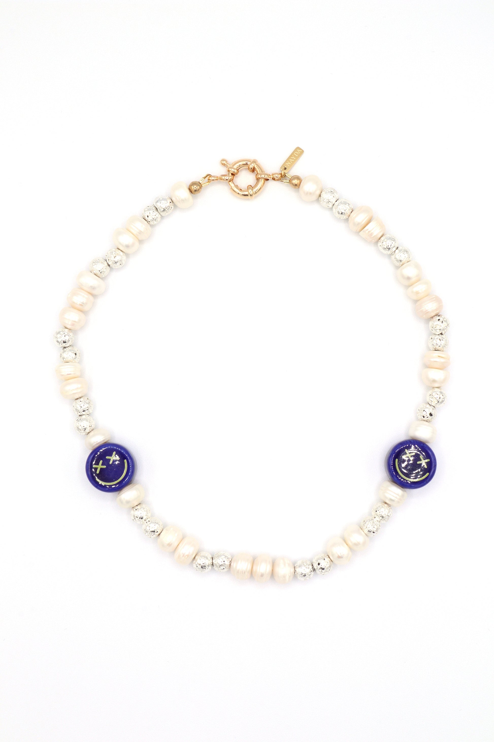 Close-up of crossed eyes ceramic smiley face necklace with lava beads and pearls