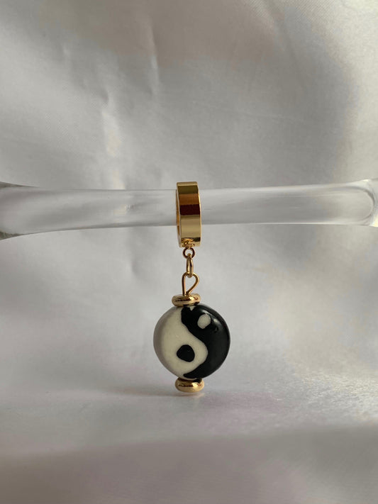 18K gold plated yin yang dangle huggies displayed on prop