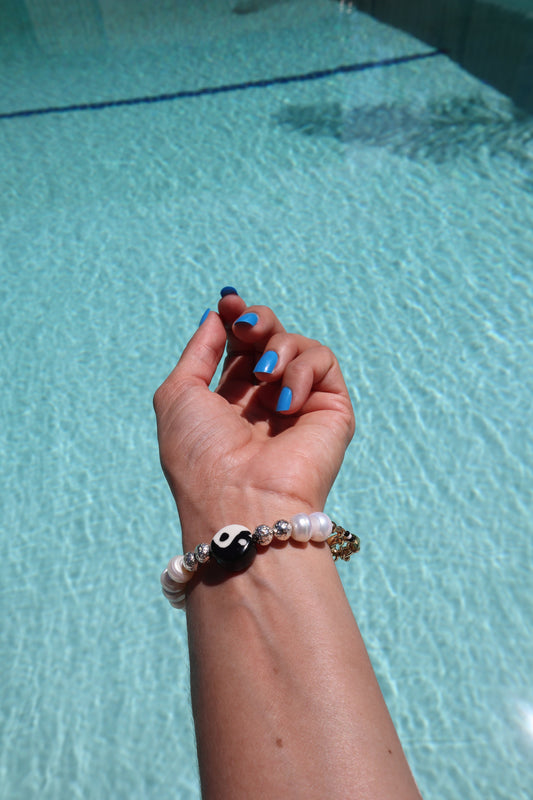 wrist shot of Ceramic yin yang bracelet with metallic lava and natural pearls