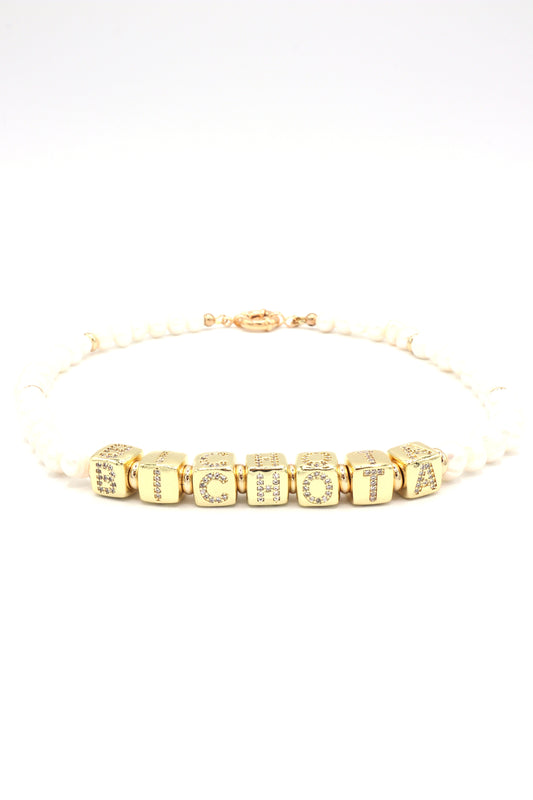 Necklace styled with ‘Bichota’ gold letters and freshwater pearls
