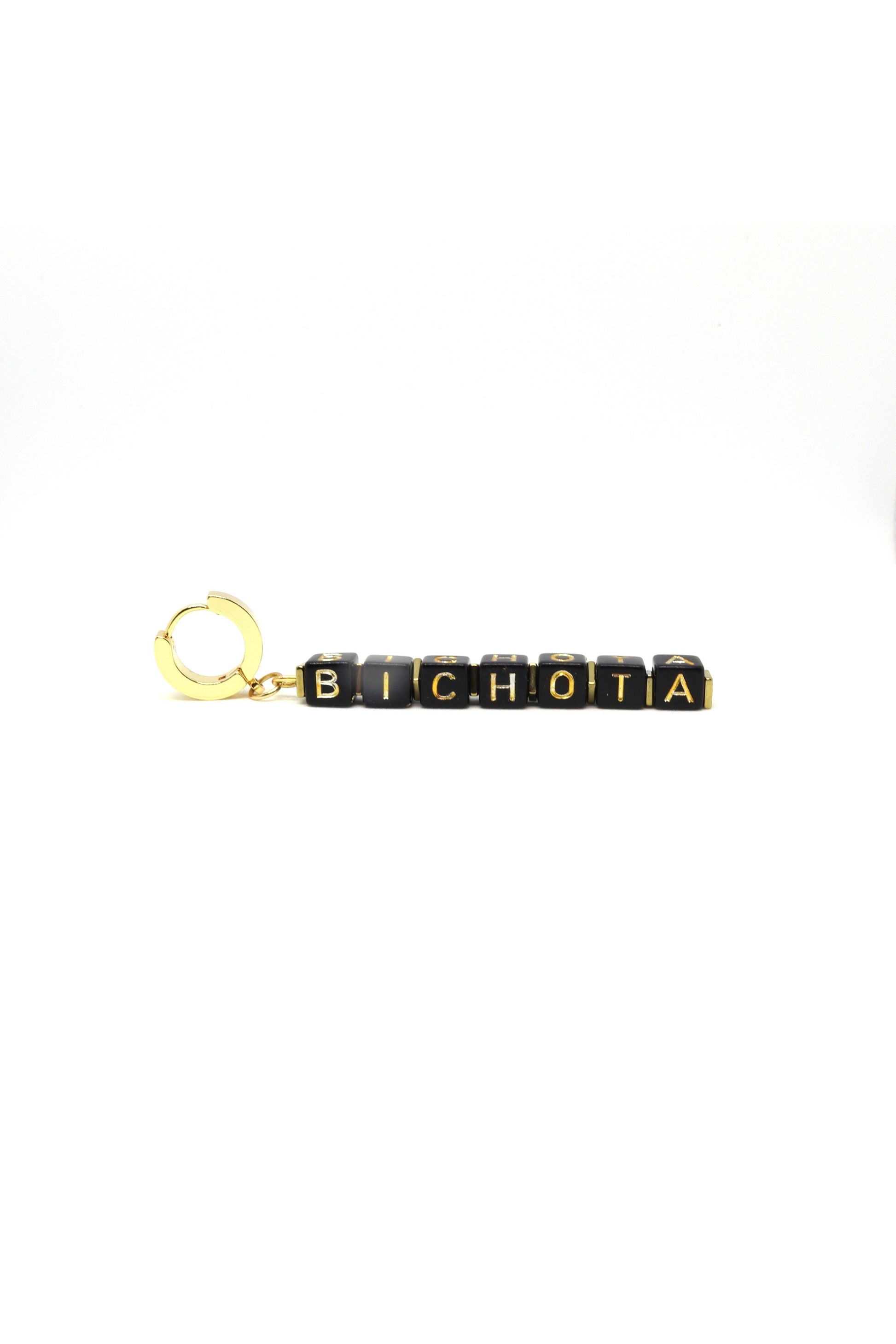Close-up of handmade “Bichota” gold earrings on white background