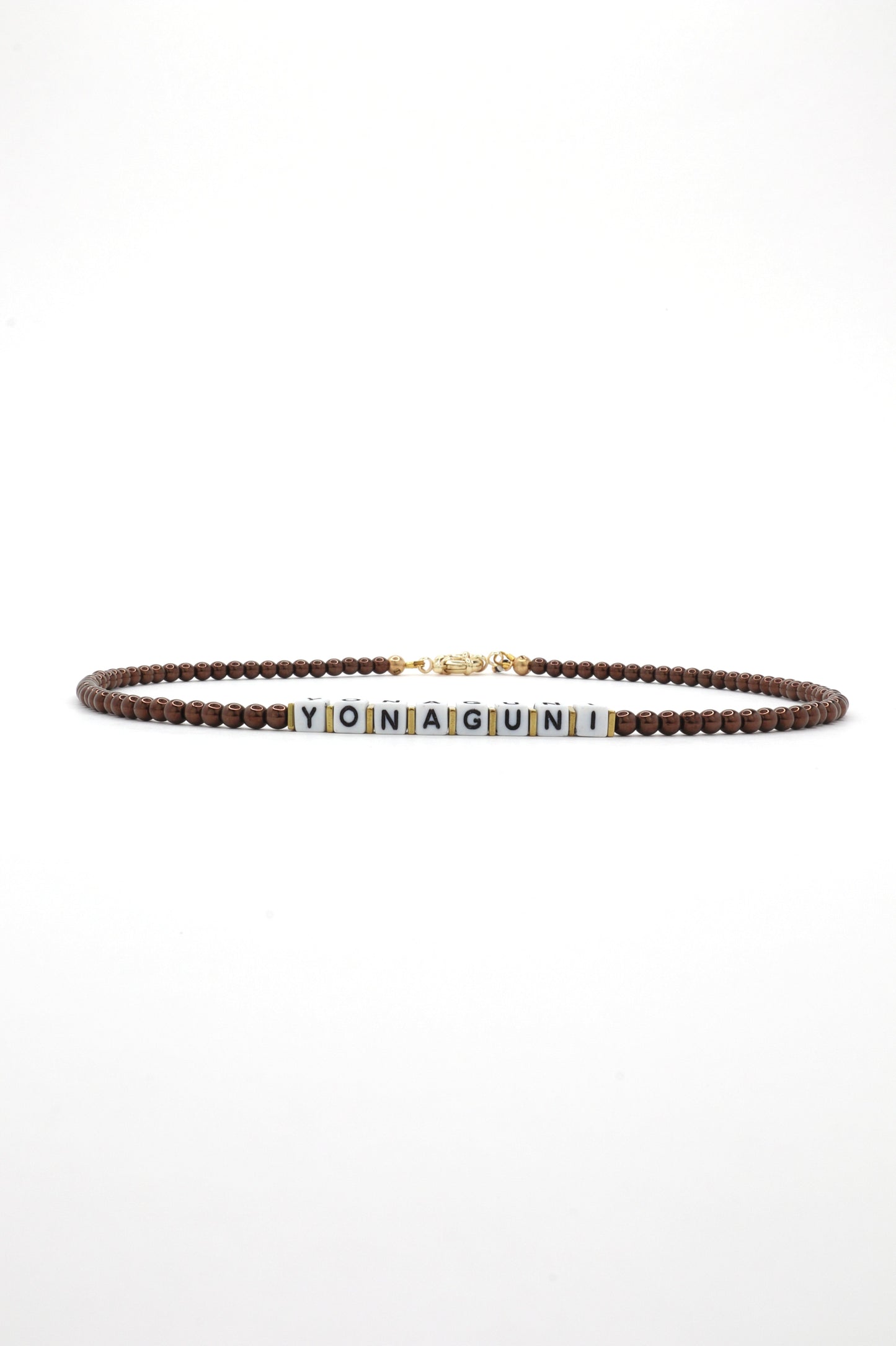 Close-up of cube letter necklace with earthy brown beads