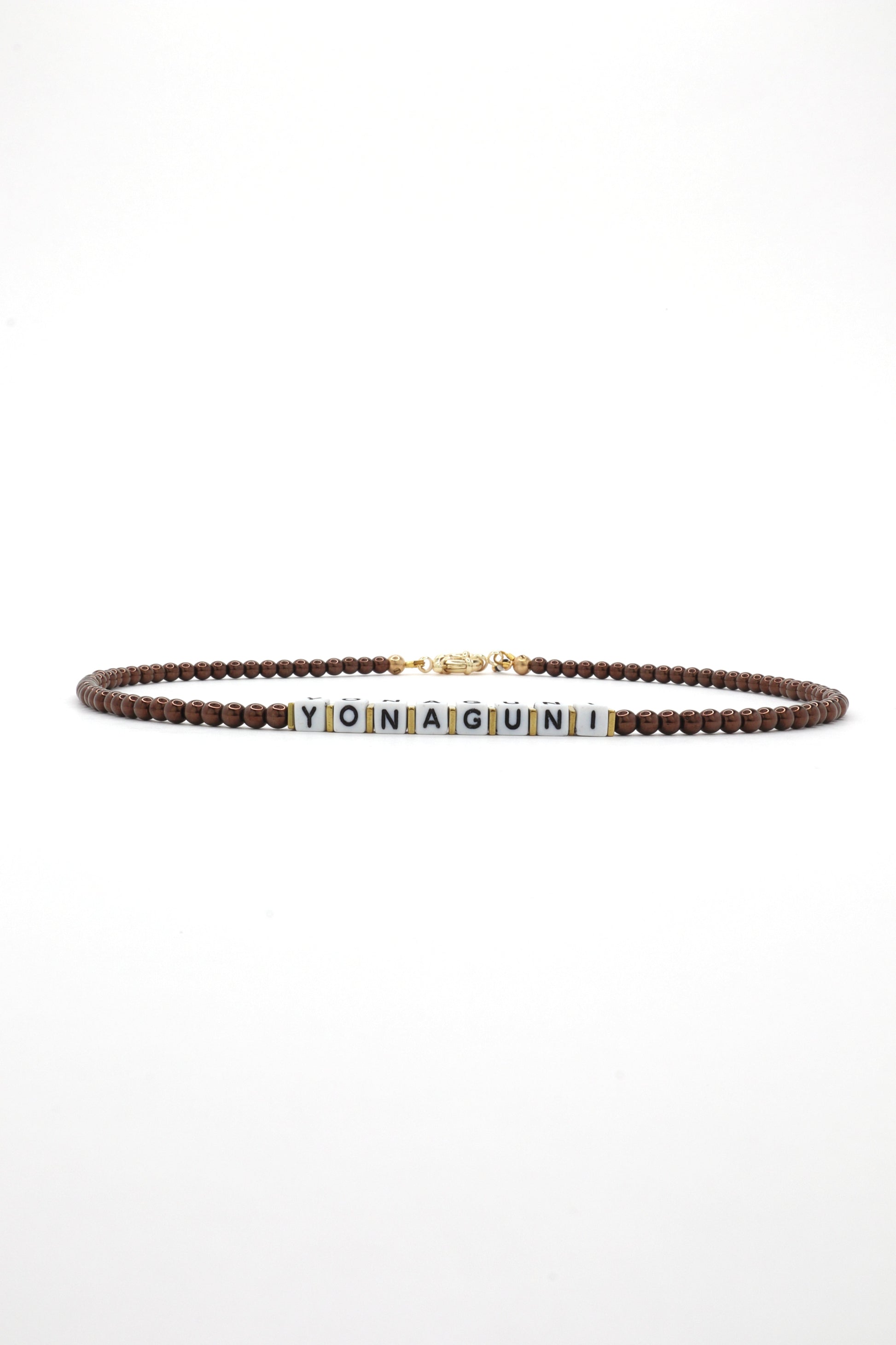 Close-up of cube letter necklace with earthy brown beads