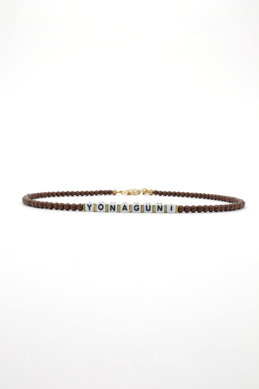 Close-up of cube letter necklace with earthy brown beads