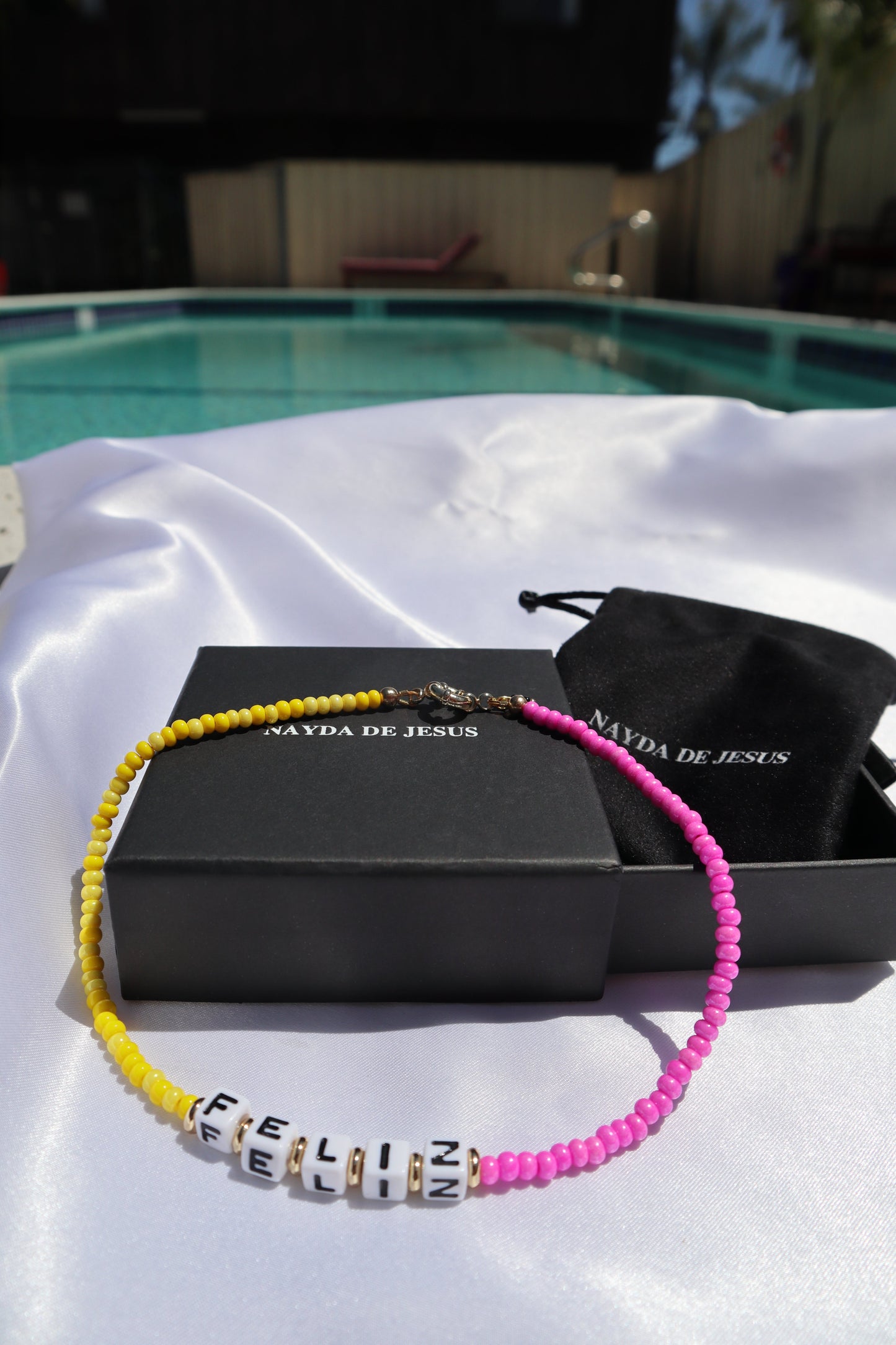customizable-cube-letters-yellow-pink-glass-beads-necklace-with-the-word-feliz-by-pool