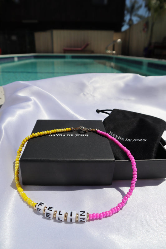 customizable-cube-letters-yellow-pink-glass-beads-necklace-with-the-word-feliz-by-pool