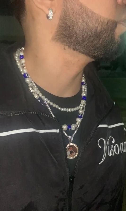 Artistic necklace with skull charm, freshwater pearls, and glass evil eye on male model