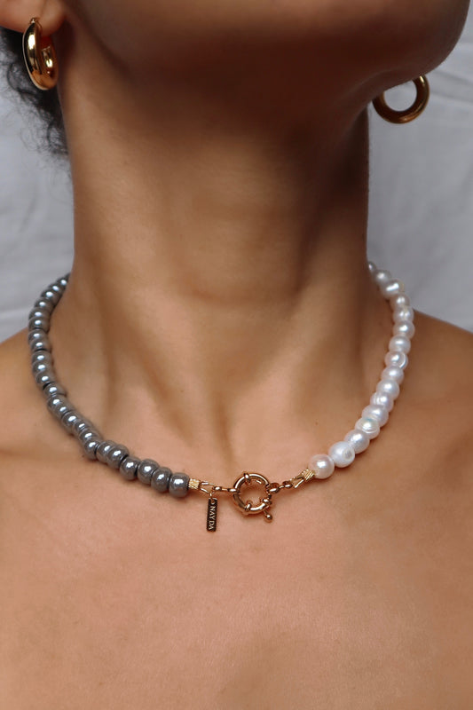 Close-up of elegant gray glass and pearl beaded necklace on model