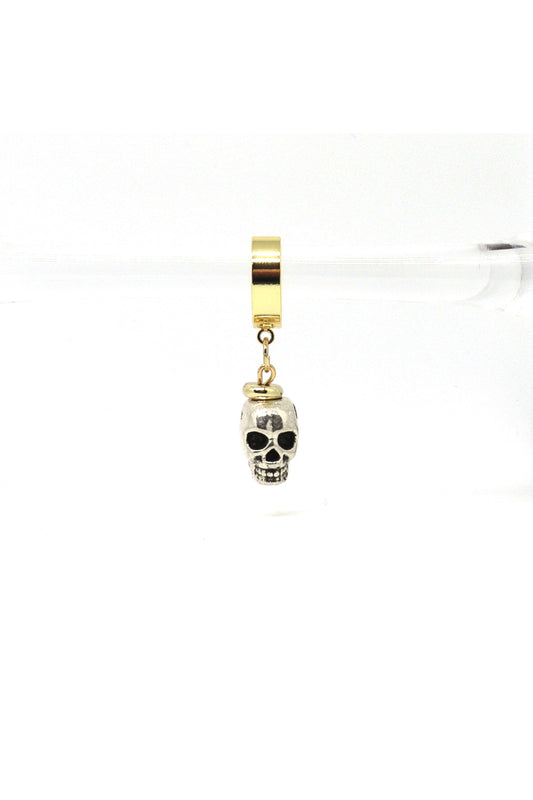 Close-up of gold skull charm earrings on white background