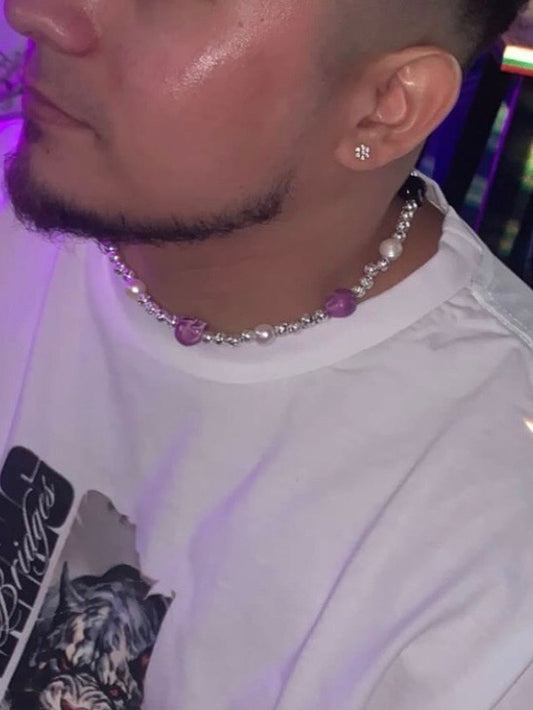 Close-up of ceramic skull necklace with freshwater pearls and silver beads on male model