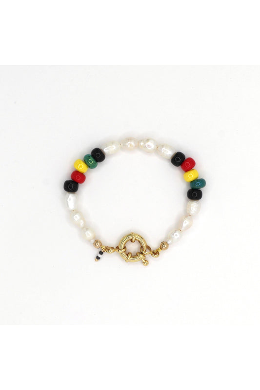 Rasta-inspired bracelet with glass beads and freshwater pearls on white background by Nayda De Jesus