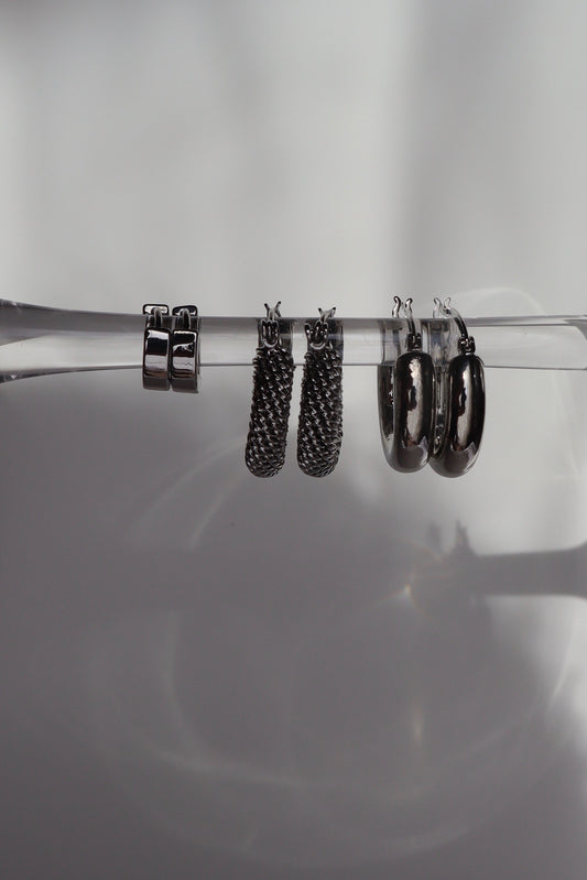 Close-up of small hoop earrings with rhodium finish on prop