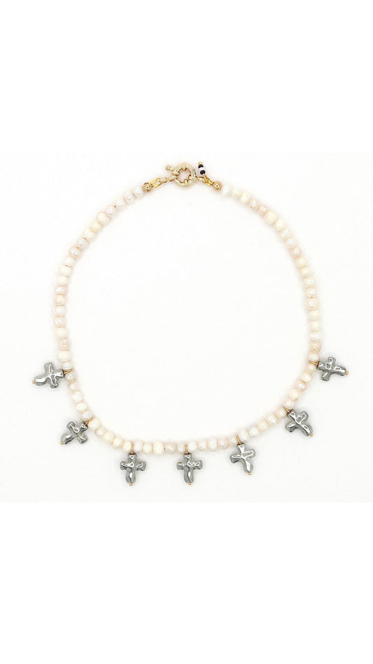 Close-up of silver cross and freshwater pearl necklace by Nayda De Jesus