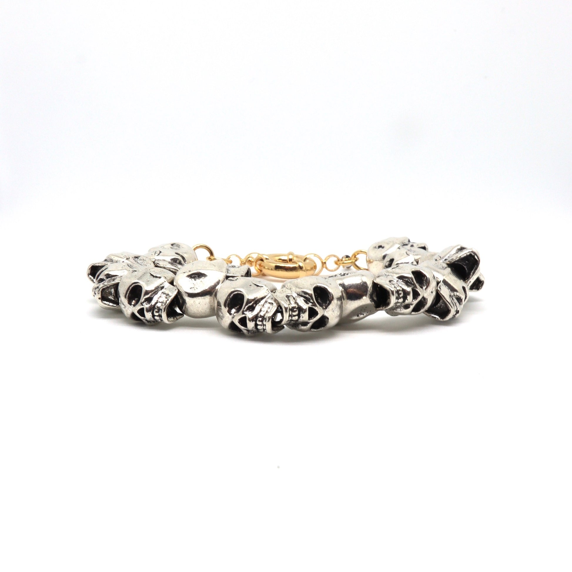 Close-up of silver skull charm bracelet on white background