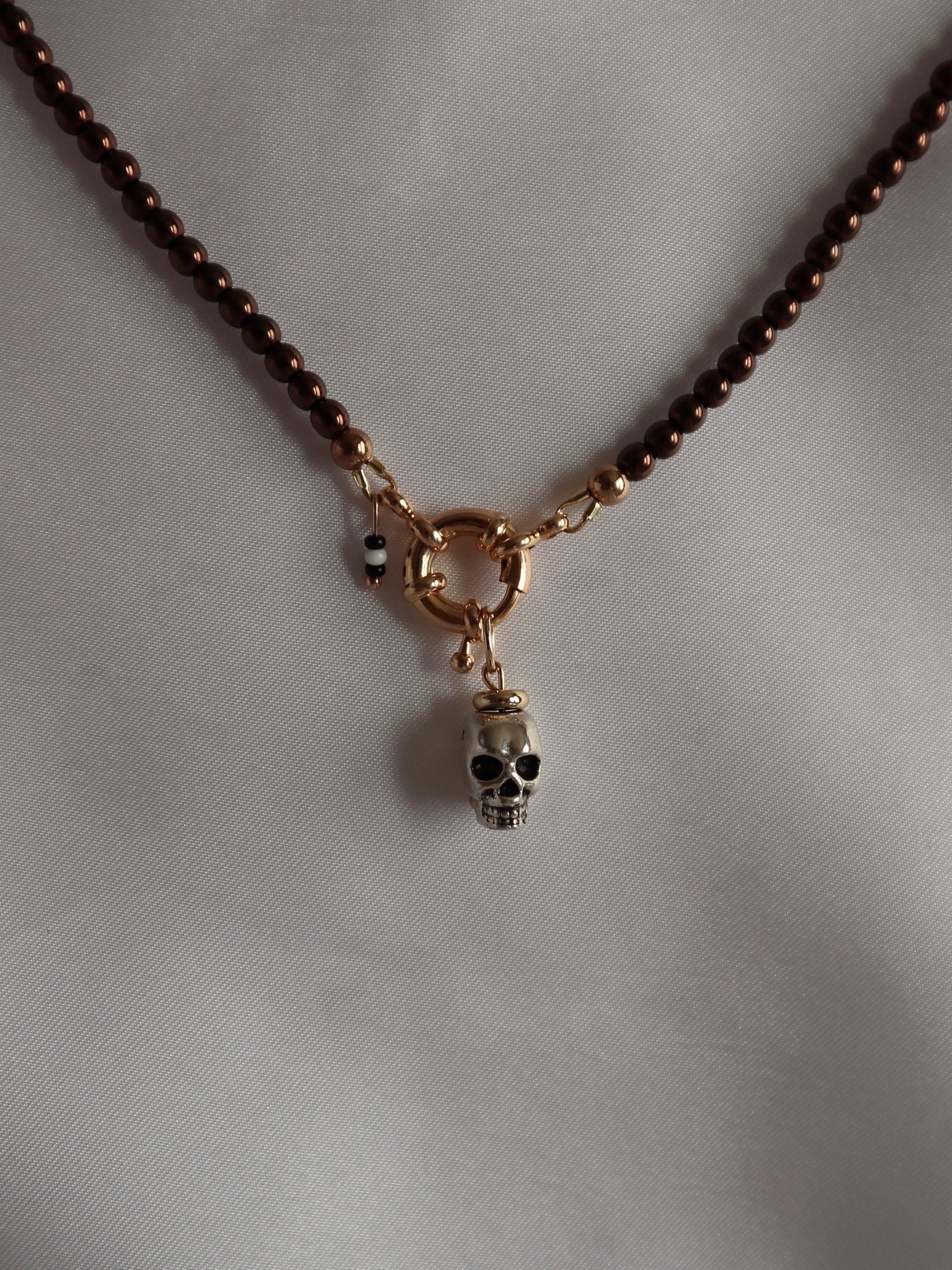 Bold metal skull charm displayed with a necklace