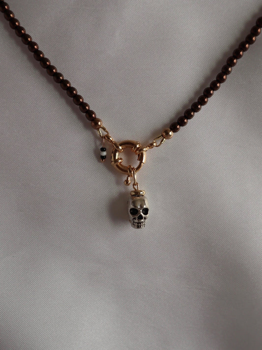 Bold metal skull charm displayed with a necklace