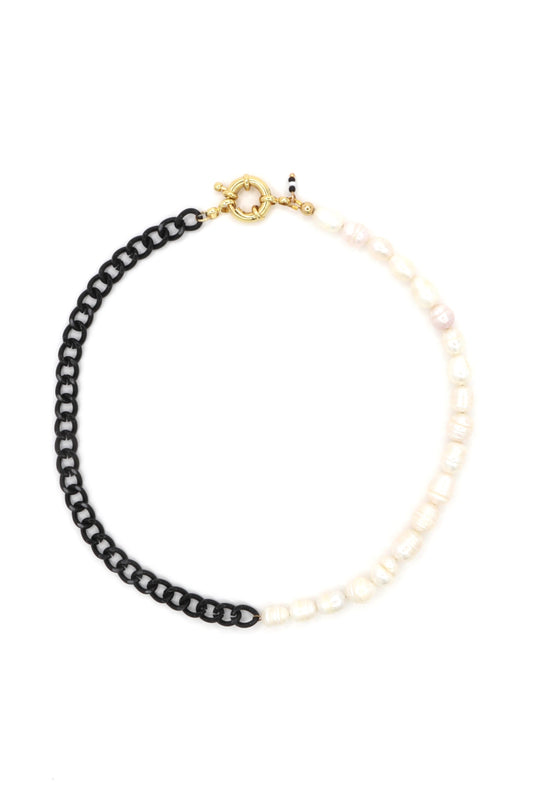 Freshwater pearls and black chain necklace laying flat on white background
