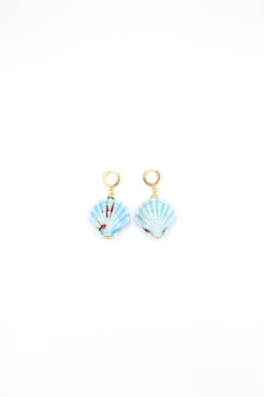 Flat lay of 18K gold plated huggie earrings with ceramic sea shells