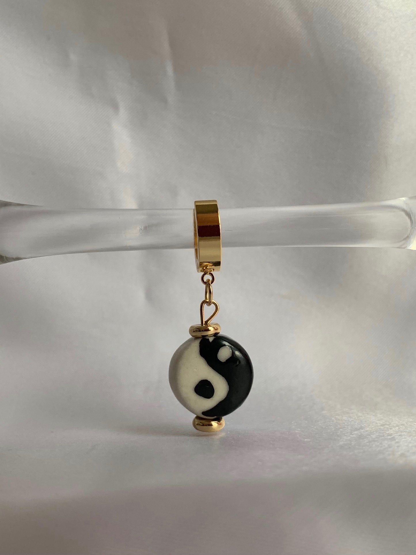 18K gold plated yin yang dangle huggies displayed on prop