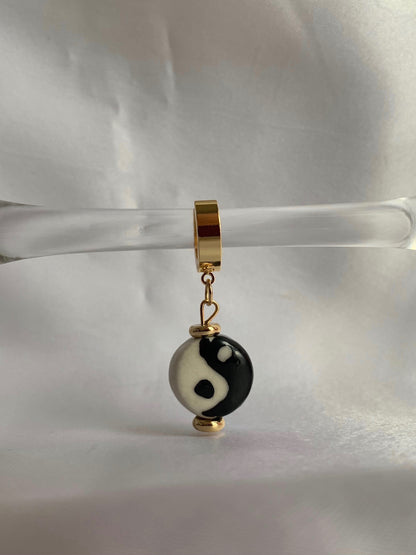 18K gold plated yin yang dangle huggies displayed on prop