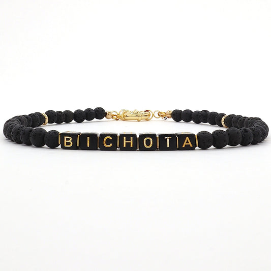 customizable-bichota-teresa-necklace-made-with-black-and-gold-cube-letters-and-black-lava-beads-along-18-k-gold-filled-spring-clasp-by-latina-artist-nayda-de-jesus