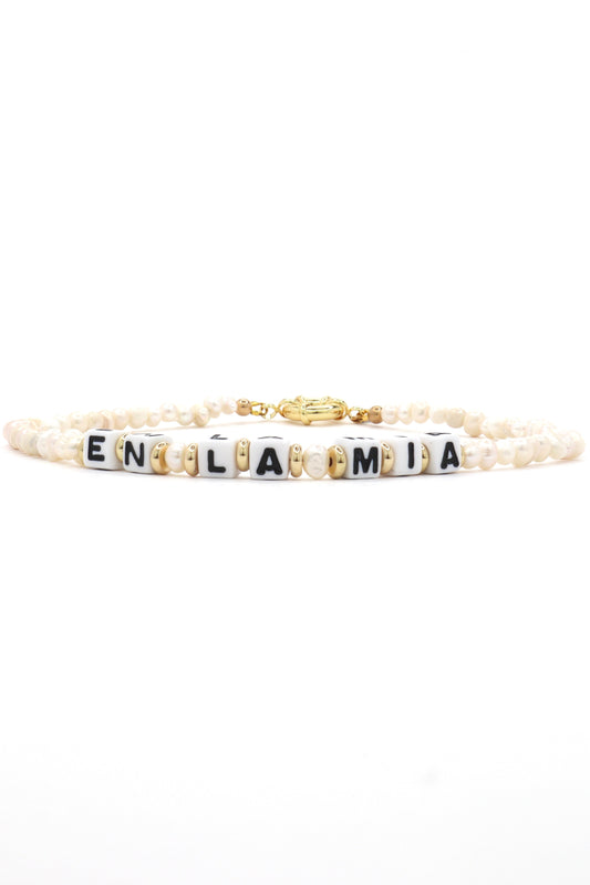 Close-up of customizable gold and pearl name necklace