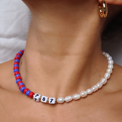 lfestyle-photo-of-customizable-nativa-necklace-made-with-freshwater-pearls-and-red-and-blue-glass-beads-along-18-k-gold-filled-spring-clasp-closure-by-latina-artist-nayda-de-jesus