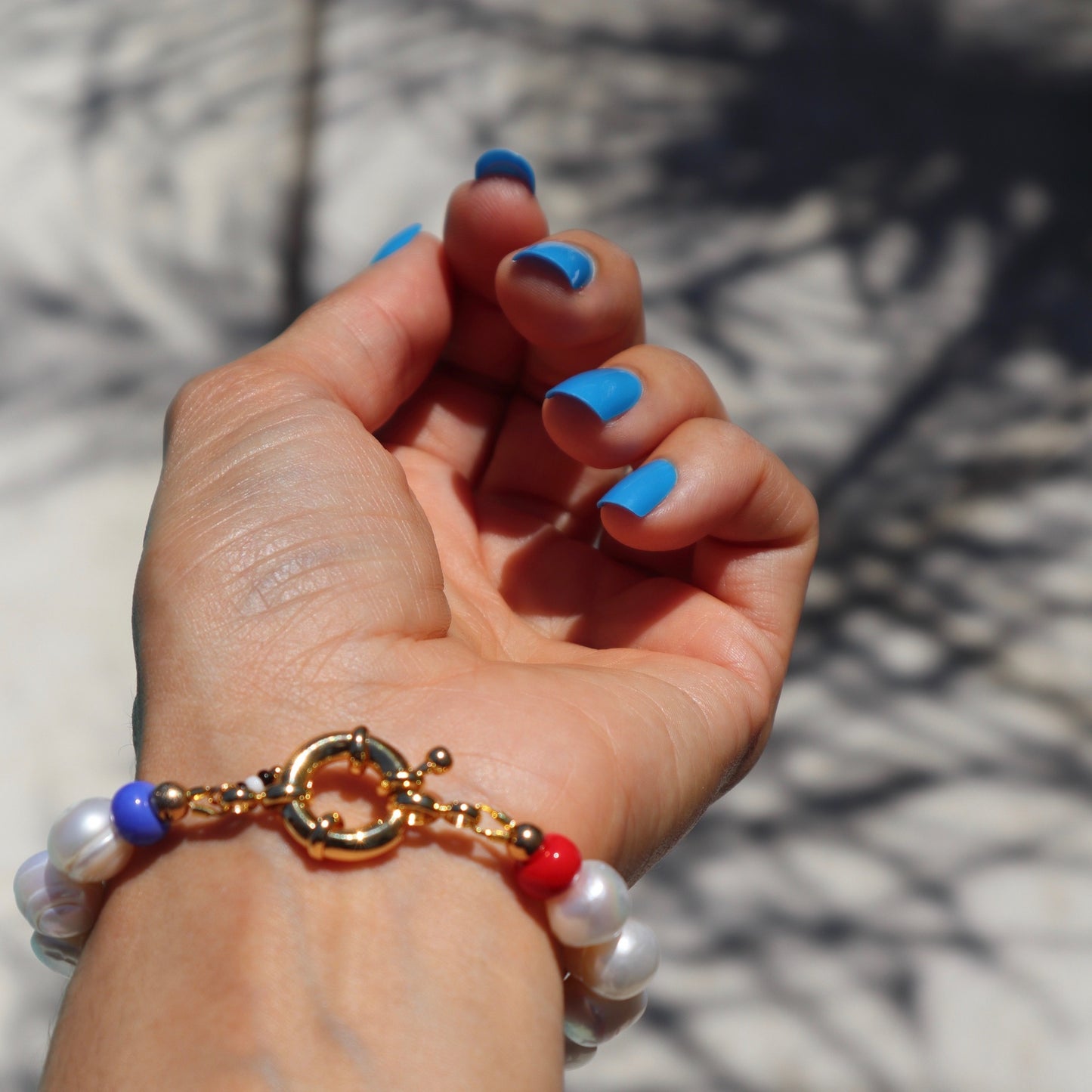 lifestyle-photo-of-franco-bracelet-hand-made-with-freshwater-pearls-blue-and-red-glass-beads-along-18-k-spring-clasp-by-latina-artist-nayda-de-jesus