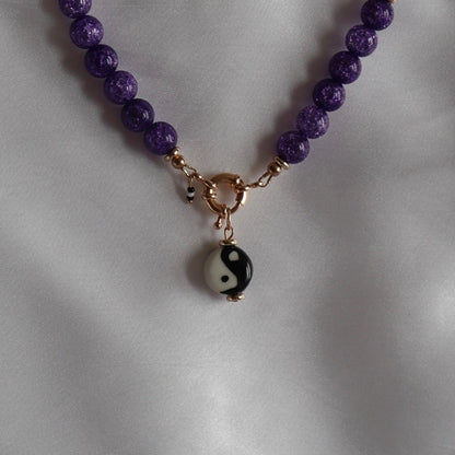 lifestyle-photo-of-daniel-yin-yang-charm-with-vitis-necklace-hand-made-with-purple-quartz-along-18-k-gold-filled-spring-clasp-closure-by-latina-artist-nayda-de-jesus