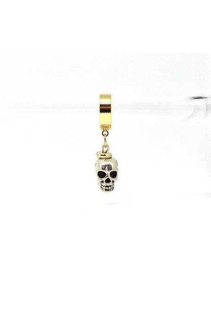 Close-up of gold skull charm earrings on white background