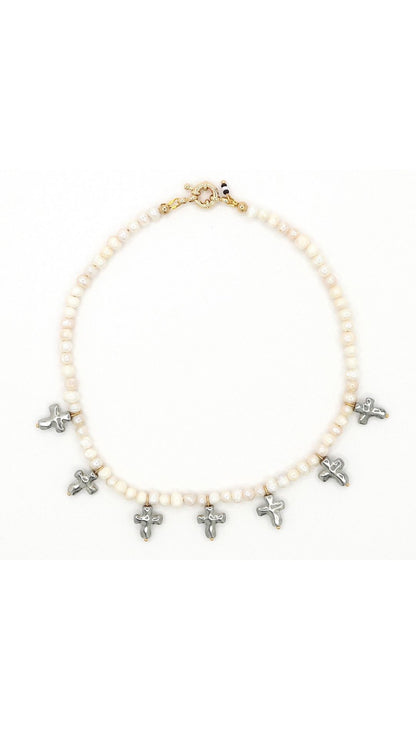 Close-up of silver cross and freshwater pearl necklace by Nayda De Jesus